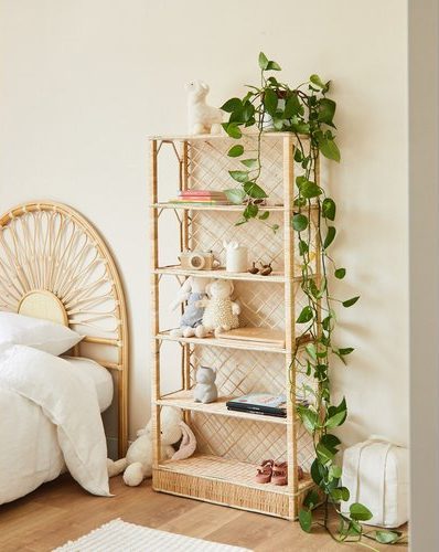 Une étagère en osier, sans rebord, ou sont posés des jouets et quelques livres