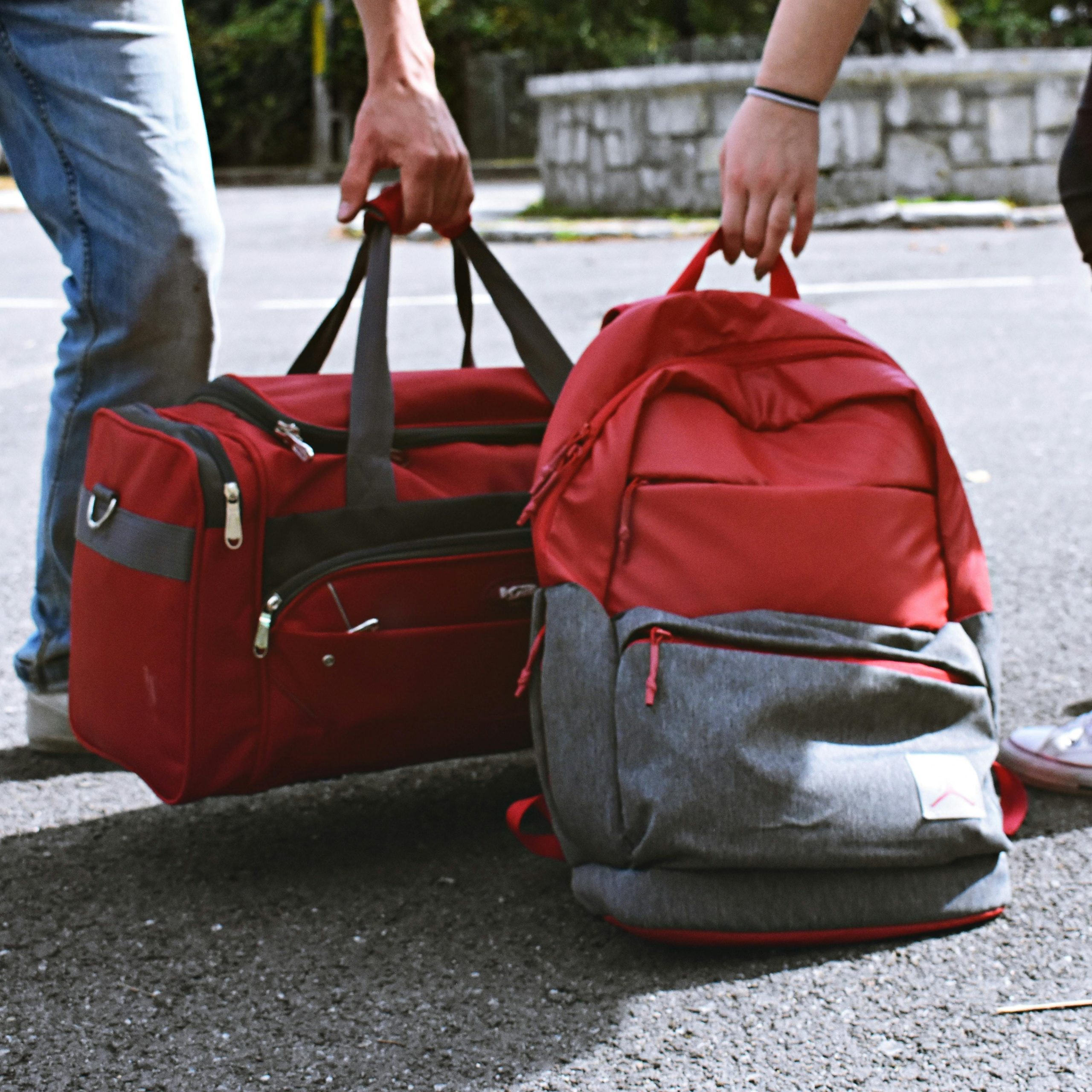 deux personnes qui portent des sacs de voyages, un sac à dos et un sac souple