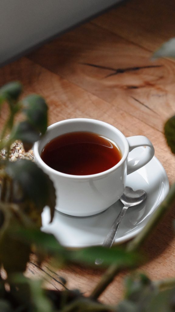 Une tasse de thé avec une cuillère en forme de cœur.
