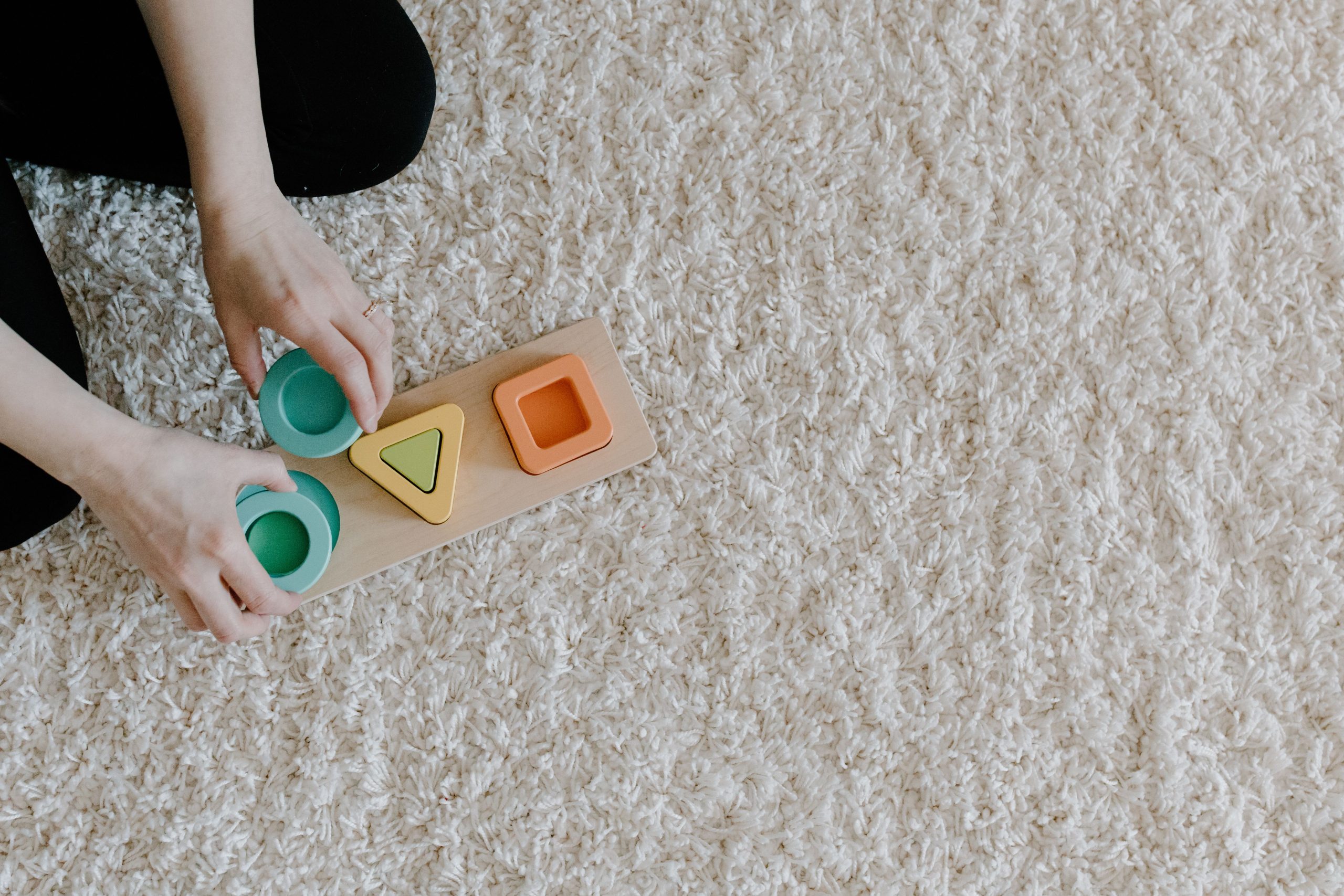 Un adulte qui complete un puzzle d'enfant.