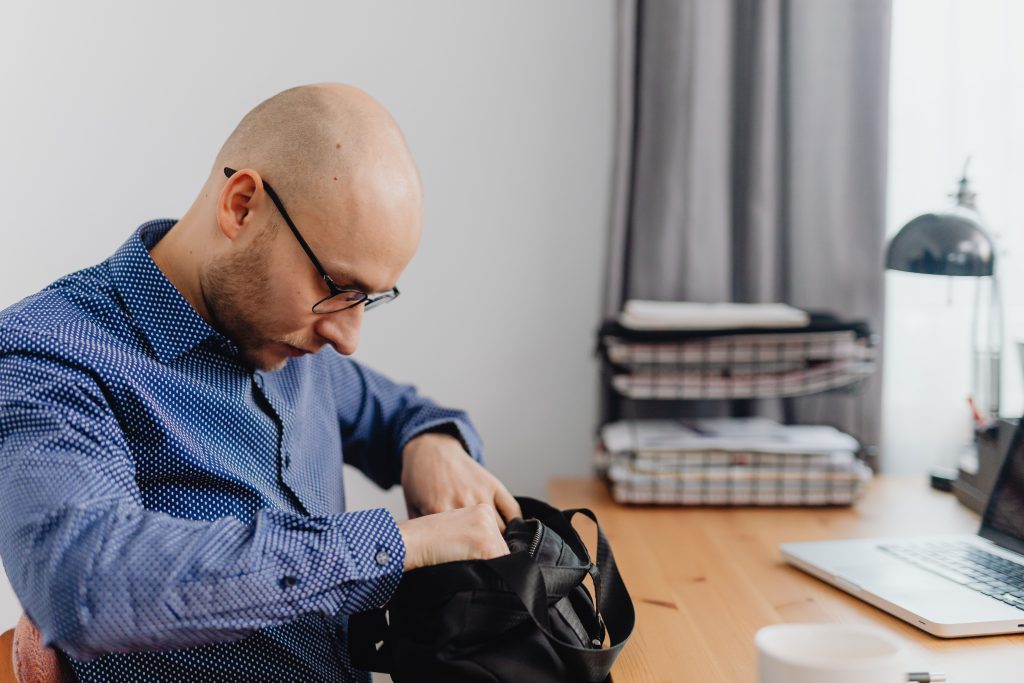 un homme fouille dans son sac de travail.