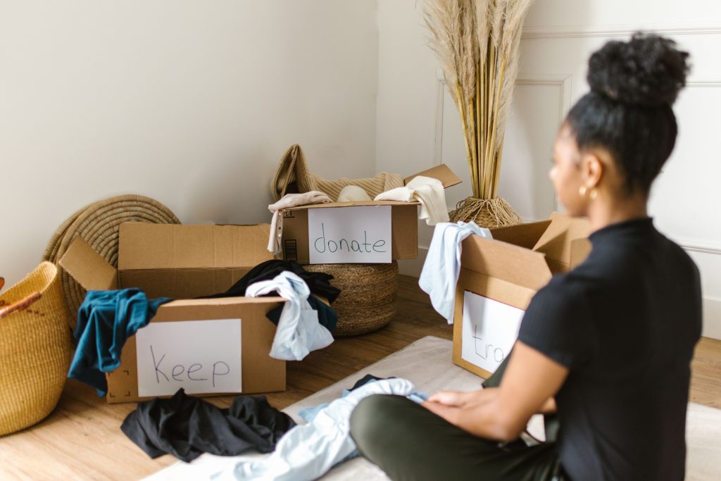 une femme devant 3 cartons utilisés pour trier